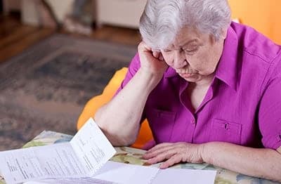 Elderly woman checking on her documents