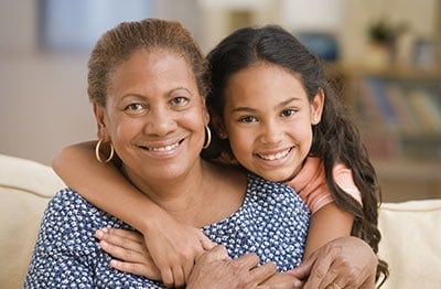 Portrait of a smiling woman and her daughter facing the camera