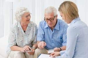 Elderly couple getting advice from a female professional representative