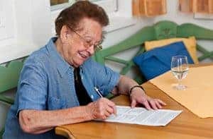 Smiling old woman writing her will